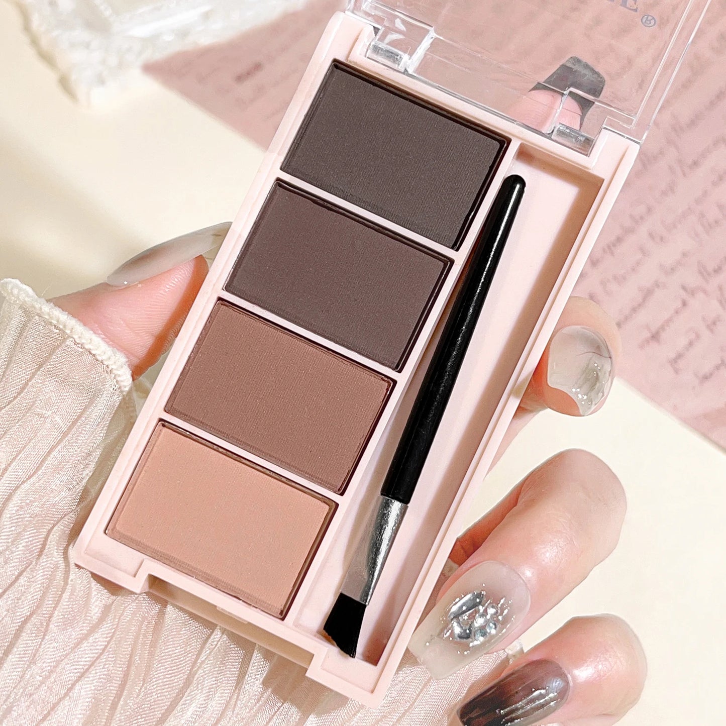 A set of 4-color eyebrow powder trays with brushes in gray and brown matte tones for long-lasting color rendering, filling and s